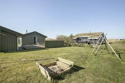 a yard with a sandbox and a house at BL758-Pandrup-Hunetorp-Klitvej-237 in Pandrup