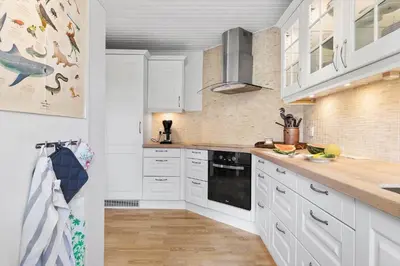 a kitchen with white cabinets and a counter top at BL1206-Blokhus-Blaabaervej-6 in Blokhus