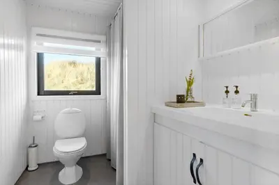 a white bathroom with a toilet and a sink at BL1529-Pandrup-Ferborgvej-58 in Pandrup