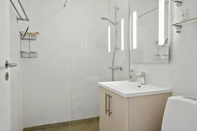 a white bathroom with a sink and a shower at BL1260-Blokhus-Strandvejen-14-Lejl-9 in Blokhus