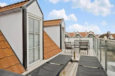 a balcony with chairs and a table on a building at BL1260-Blokhus-Strandvejen-14-Lejl-9 in Blokhus