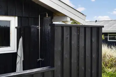 a black fence with a shower on the side of a house at BL687-Saltum-Porsevej-16 in Saltum