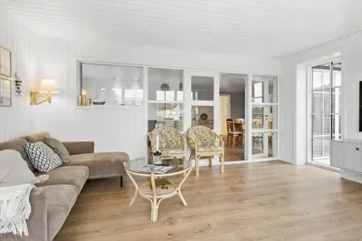a living room with a couch and a table and chairs at BL1246-Blokhus-Vigen-6 in Blokhus
