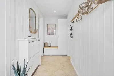 a hallway with a bathroom with a sink and a mirror at BL1246-Blokhus-Vigen-6 in Blokhus
