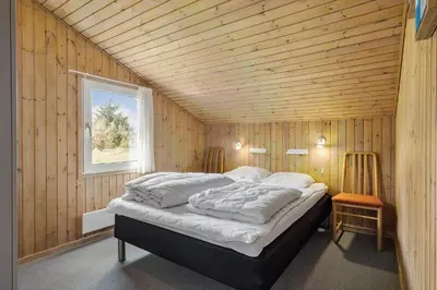 a bedroom with a bed in a wooden wall at BL1781-Saltum-Ornebjergvej-26 in Saltum