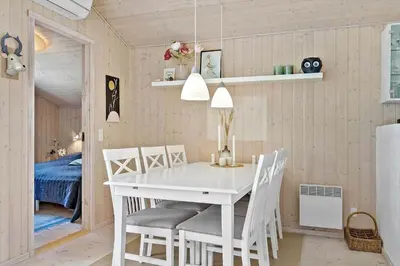 a dining room with a white table and chairs at BL1700-Blokhus-Bloksbjerg-55 in Blokhus