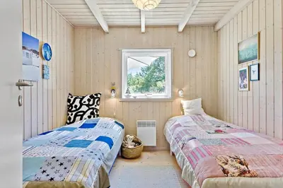 a bedroom with two beds and a window at BL1700-Blokhus-Bloksbjerg-55 in Blokhus