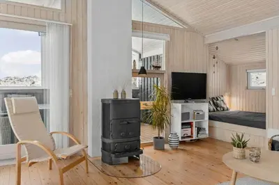 a living room with a wood stove and a couch at BL1620-Saltum-Foraarsvangen-7 in Saltum