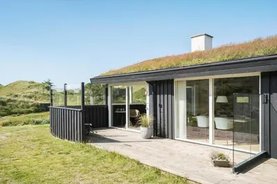 a house with a grass roof with a wooden deck at BL1620-Saltum-Foraarsvangen-7 in Saltum