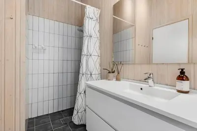a bathroom with a white sink and a mirror at BL1620-Saltum-Foraarsvangen-7 in Saltum