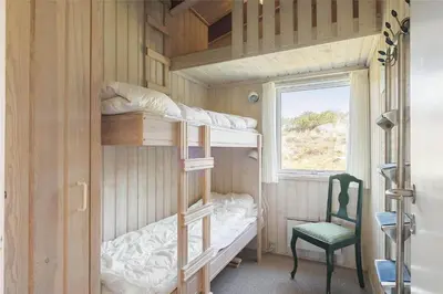 a small room with bunk beds and a chair at BL1419-Saltum-Skanderborgvej-13 in Saltum