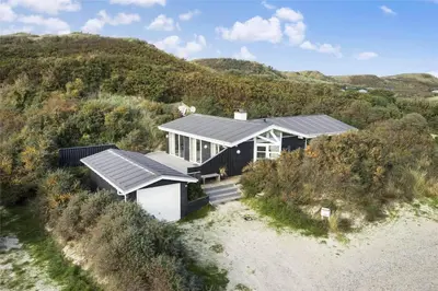 a house with a solar roof on a beach at BL1156-Blokhus-Ankerhusvej-44 in Blokhus
