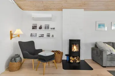 a living room with a chair and a fireplace at BL1156-Blokhus-Ankerhusvej-44 in Blokhus