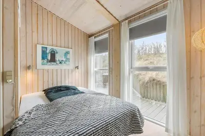 a bedroom with a bed in front of a window at BL1156-Blokhus-Ankerhusvej-44 in Blokhus