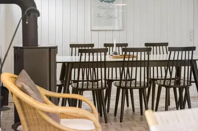 a dining room with a table with chairs and a stove at BL253-Blokhus-Jaegerbakken-9 in Blokhus