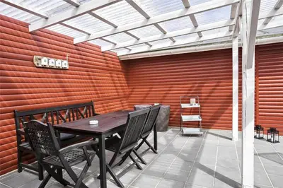 a patio with a table and chairs and a wall at BL253-Blokhus-Jaegerbakken-9 in Blokhus