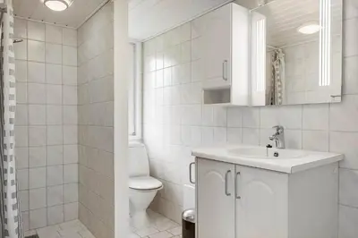 a white bathroom with a toilet and a sink at BL253-Blokhus-Jaegerbakken-9 in Blokhus