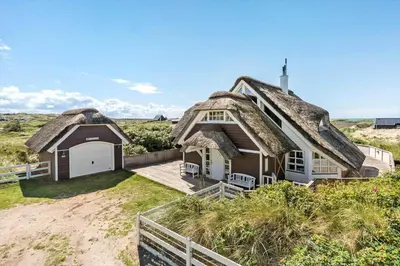 a house with a thatched roof on a beach at BL1647-Saltum-Graabakken-46 in Saltum