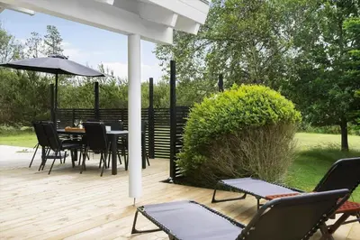 a patio with a table and chairs and an umbrella at BL485-Blokhus-Sandtoften-29 in Blokhus