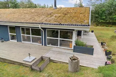 a house with a wooden deck in the yard at BL1200-Blokhus-Plantagevej-6-C in Blokhus