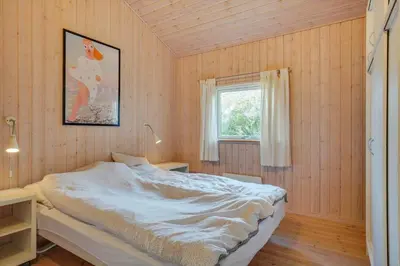 a bedroom with a bed and a window at BL813-Blokhus-Klitvejen-12 in Blokhus