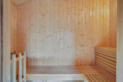 a sauna with a wooden wall and a wooden stairs at BL813-Blokhus-Klitvejen-12 in Blokhus