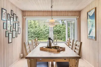 a dining room with a wooden table and a window at BL1332-Pandrup-Rodhusparken-78 in Pandrup