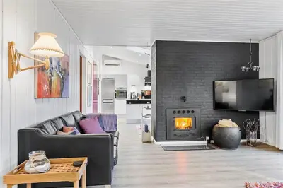 a living room with a couch and a fireplace at BL1767-Saltum-Saltum-Strandvej-209 in Saltum