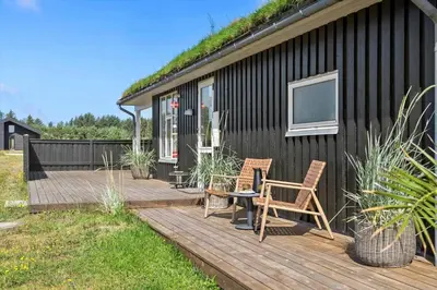 a wooden deck with two chairs and a table at BL806-Saltum-Laustvej-8 in Saltum