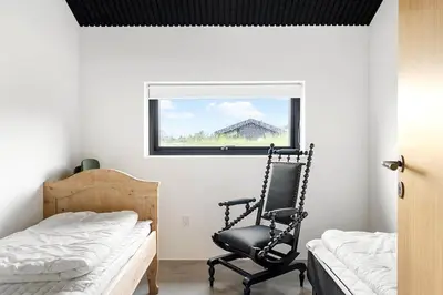 a bedroom with a chair and a bed and a window at BL1364-Saltum-Tolhoj-34 in Saltum