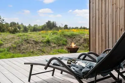 a rocking chair sitting on a porch with a view of a field at BL1364-Saltum-Tolhoj-34 in Saltum