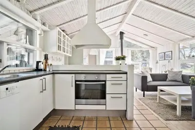 a kitchen with white appliances and a living room at BL583-Saltum-Saltum-Strandvej-210 in Saltum