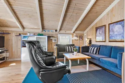 a living room with a blue couch and a table at BL331-Saltum-Ornebjergvej-21 in Saltum