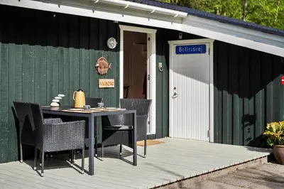 a patio with a table and chairs outside of a building at BL1466-Pandrup-Lunekrogen-14 in Pandrup