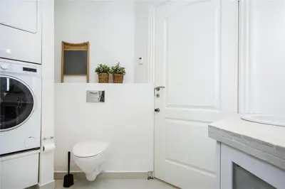 a white bathroom with a toilet and a washing machine at BL139-Blokhus-Klitvejen-4-A in Blokhus