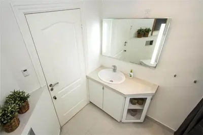 a white bathroom with a sink and a mirror at BL139-Blokhus-Klitvejen-4-A in Blokhus