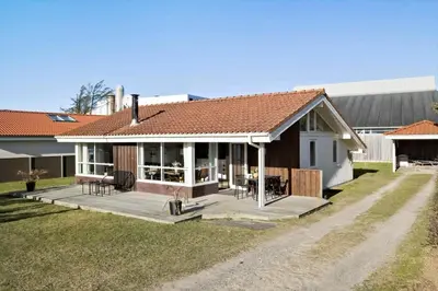 a house with a large deck in the yard at BL222-Blokhus-Jens-Baerentsvej-16 in Blokhus