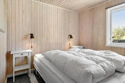a bedroom with a large bed and two night stands at BL1601-Blokhus-Kristinesvej-15 in Blokhus