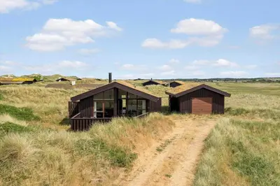 two small buildings in a field with a dirt road at BL1591-Pandrup-Ferborgvej-54 in Pandrup