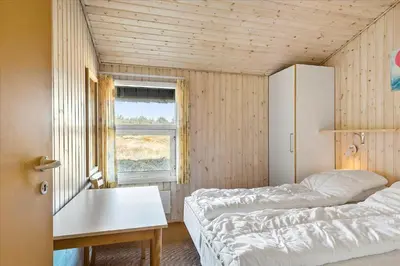 a bedroom with two beds and a table and a window at BL1749-Pandrup-Tunen-5 in Pandrup