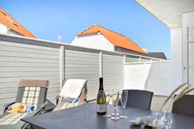 a table with two bottles and glasses on a patio at BL1520-Blokhus-Klitgaardsvej-3-B in Blokhus