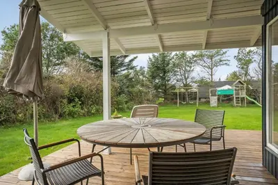 a patio with a table and chairs on a deck at BL1152-Blokhus-Septimusvej-28 in Blokhus