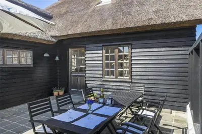 a table and chairs on the patio of a house at BL982-Pandrup-Hunetorp-Klitvej-156 in Pandrup