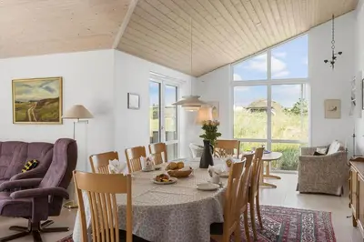 a dining room with a table and chairs at BL1564-Blokhus-Ved-Skoven-8 in Blokhus