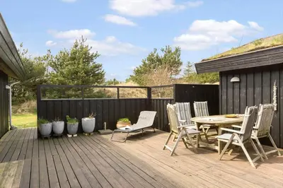a wooden deck with a table and chairs on it at BL1696-Saltum-Kordalslien-9 in Saltum