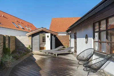a wooden deck with two chairs on a house at BL1527-Blokhus-Svinget-5 in Blokhus