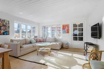 a living room with a couch and a table at BL1527-Blokhus-Svinget-5 in Blokhus