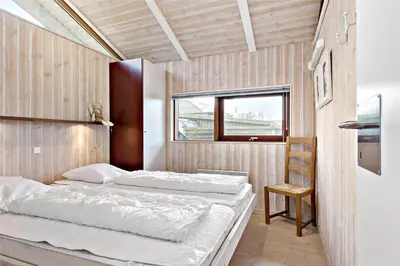 a bedroom with two beds and a window at BL236-Blokhus-Pirupshvarrevej-27 in Blokhus