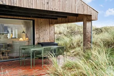a house with two chairs and a table on a patio at BL1314-Pandrup-Nordvej-11 in Pandrup