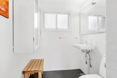 a white bathroom with a toilet and a sink at BL1612-Blokhus-Jens-Baerentsvej-3 in Blokhus